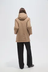 Campera de abrigo color beige, con capucha, cierre frontal con botones a presión y diseño de corte recto y holgado.