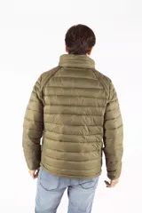 Campera puffer de diseño acolchado en color azul oscuro, con cuello elevado, cierre frontal completo y bolsillos laterales con cierre. Incluye un bolsillo adicional en el pecho y capucha oculta.