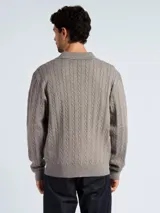 Sweater tipo polo de punto con diseño de trenzas, color azul marino, con cuello clásico y abertura frontal.