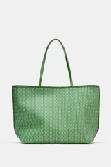 Bolso de hombro tipo shopper de color verde con cuerpo estampado geométrico, doble asa de hombro fina y detalles de pespuntes a contraste. Cuenta con compartimento interior con cremallera y cierre mediante botón imantado.