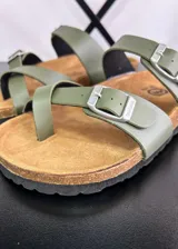 Sandalias planas color verde militar, con dos tiras anchas ajustables con hebilla metálica plateada y plantilla de corcho.