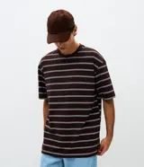 Remera de corte relajado confeccionada en mezcla de algodón y poliéster, con diseño de rayas horizontales en tonos marrón, blanco y celeste. Presenta cuello redondo y mangas cortas.