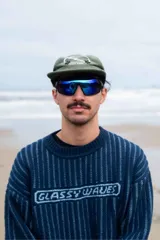 Lentes de sol deportivos con marco negro envolvente y cristales espejados en tono azul verdoso.