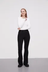 Pantalon jean de tiro alto con corte flare y terminación desflecada en el ruedo. Presenta un diseño clásico de cinco bolsillos con costuras en contraste.