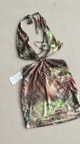 Vestido corto con estampado tropical en tonos marrones y verdes, escote halter pronunciado, diseño cut-out en los laterales y nudo central.