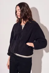 Campera negra de micropolar con cierre frontal y bolsillos laterales.