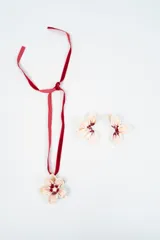 Set compuesto por un collar con cinta de terciopelo rojo y dije en forma de flor esmaltada, y un par de aros haciendo juego con el mismo diseño floral.