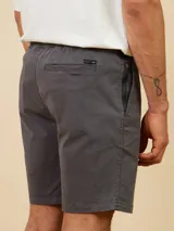 Bermuda de gabardina color gris oscuro, corte recto, con bolsillos laterales tipo cargo con botón a presión.