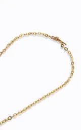 Collar largo de cadena de eslabones dorados con dije central ovalado de piedra verde engarzada en metal dorado.