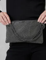 Cartera de strass color negro, con cierre metálico y bolsillo interior. Incluye una correa de mano trenzada y un cierre de cremallera.