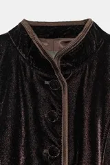 Blazer de terciopelo en color rosado con cuello subido y manga larga. Presenta cierre frontal con botones forrados y detalles de vivo en color oscuro a contraste en los bordes, cuello y puños. Incluye bolsillos delanteros de vivo.