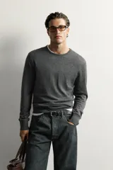 Jersey regular fit de punto ligero color gris oscuro, tejido en hilatura de lana con cuello redondo, manga larga y acabados en rib.