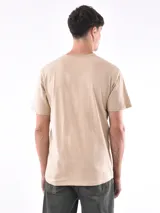 Remera de corte regular, color beige, con cuello redondo y mangas cortas.