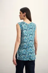 Blusa sin mangas con estampado abstracto en tonos verde y beige.