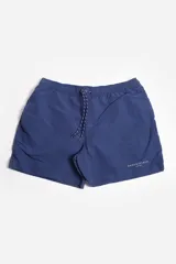 Short de baño liso color azul marino, con cintura elástica y cordón de ajuste trenzado blanco y azul. Posee bolsillos laterales y suspensor interno.