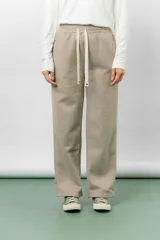 Pantalón deportivo de corte wide leg con caída relajada. Presenta cintura elastizada con cordón ajustable, bolsillos laterales y un interior frizado para mayor abrigo.
