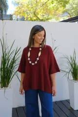 Sweater de punto color bordó, con cuello redondo, manga corta amplia y diseño holgado.