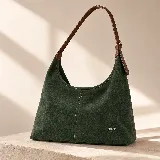 Cartera tipo hobo de gamuza verde oscuro, con textura grabada y costuras pespunteadas a la vista. Cuenta con una correa de hombro ajustable de cuero sintético marrón, detalles metálicos dorados y la marca 'chérie' grabada en la parte inferior frontal.