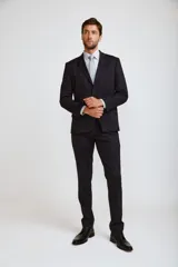Ambo formal compuesto por saco de dos botones y pantalón de vestir a juego, en color negro. El saco presenta solapas clásicas y bolsillos laterales con solapa.