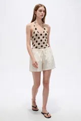 Short de lino color blanco de tiro medio, con bolsillos laterales y cintura elástica con cordón de ajuste.