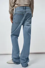 Pantalón de jean celeste de tiro alto, corte recto y largo hasta el tobillo. Tiene cinco bolsillos, trabillas en la cintura, efecto lavado y cierre frontal con cremallera y botón.