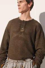Camiseta de punto con estructura abierta tipo crochet, de corte relajado, cuello panadero con cierre frontal de botones y manga larga.