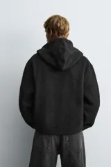 Sobrecamisa de corte relajado confeccionada en tejido con textura efecto pelo. Presenta cuello con capucha, manga larga, bolsillos laterales y cierre frontal con cremallera.