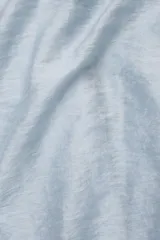 Falda larga hasta el tobillo color celeste, confeccionada en tejido arrugado liviano con cintura elástica.