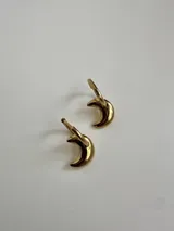 Aros de acero quirúrgico dorados con diseño dos en uno, que incluyen argollas pequeñas y dijes colgantes en forma de luna creciente.