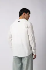 Camisa de manga larga confeccionada en tejido de lino con textura, de corte holgado y diseño versátil con cierre frontal de botones.