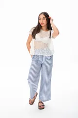 Pantalón largo a rayas verticales azules y blancas, con botón de coco, cintura elastizada y plizado en el bolsillo.