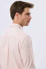 Camisa de lino a rayas finas en tonos beige y blanco, de manga larga con puños vueltos, cuello camisero y cierre frontal de botones. Cuenta con un pequeño logo bordado en el pecho.