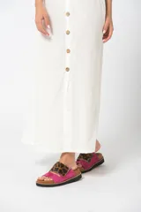 Sandalias bajas con base color suela, tira ancha de cuero fucsia y tira superior de animal print.