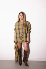 Camisa oversize a rayas celestes y blancas, con cuello camisero, manga larga y hilera de botones dorados metálicos.