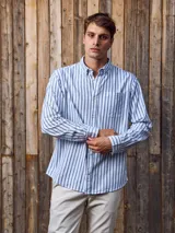Camisa de manga larga a rayas verticales azules y blancas, con cuello abotonado, bolsillo en el pecho y corte regular.