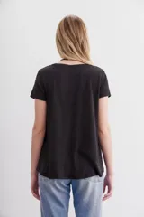 Remera básica de corte holgado, manga corta y cuello redondo, confeccionada en algodón peruano con textura jaspeada de color morado. Presenta un diseño de largo irregular con ruedo redondeado.
