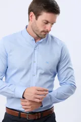 Camisa lisa de color celeste, confeccionada en 100% algodón, con cuello mao y cierre frontal de botones.