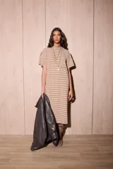 Vestido midi de algodón con diseño a rayas horizontales en color marrón y blanco. Presenta un corte holgado, cuello redondo, mangas cortas con hombros caídos y un pequeño bolsillo frontal en el pecho.