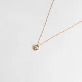 Conjunto compuesto por cadena fina y dije circular con circonia central engastada en oro 18k.