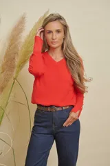 Buzo tejido color rojo, con escote en V, manga larga con detalle de botones en los puños y tajos laterales.