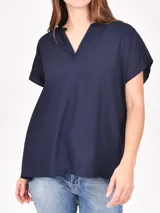Blusa azul marino de corte holgado, con cuello en V y mangas cortas.