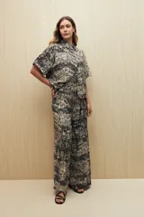 Pantalón ancho de viscosa con estampado a rayas verticales blancas sobre fondo negro, cintura elastizada y caída fluida.