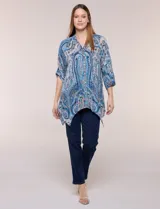 Blusa holgada de poliéster con estampado de arabescos en tonos azules, escote en V con botones frontales, mangas 3/4 y ruedo asimétrico en punta.