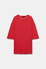 Remera oversize de punto rojo, con cuello redondo y mangas de largo medio por debajo del codo, diseño holgado y amplio.