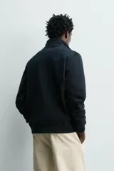 Sudadera de algodón color negro, de corte regular fit, con cuello alto, cierre frontal de cremallera bidireccional y bolsillos frontales de vivo.