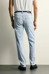 Jeans slim fit de tiro medio, color celeste claro con efecto lavado. Confeccionados en tejido elástico, cuentan con diseño de cinco bolsillos y cierre frontal con cremallera y botón metálico.