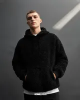 Canguro color marrón claro, con capucha y cordones ajustables, forrado con polar y reguladores en la cintura para ajustarlo.