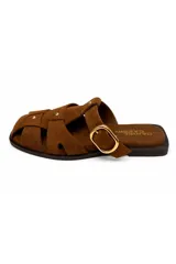 Zueco de gamuza negra con diseño trenzado tipo fisherman, hebilla metálica dorada y tachas decorativas.