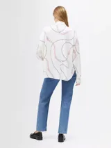 Blusa blanca hueso con estampado de cadenas en tonos negro y rosa, cuello alto con lazada ancha integrada, corte regular y manga larga.