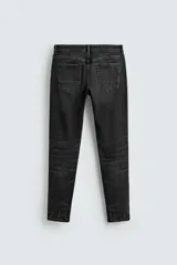 Jeans skinny fit de corte ajustado y tiro medio en color negro con efecto lavado y detalles desgastados. Confeccionados en tejido elástico con mezcla de algodón, presentan diseño clásico de cinco bolsillos y cierre frontal con cremallera y botón.